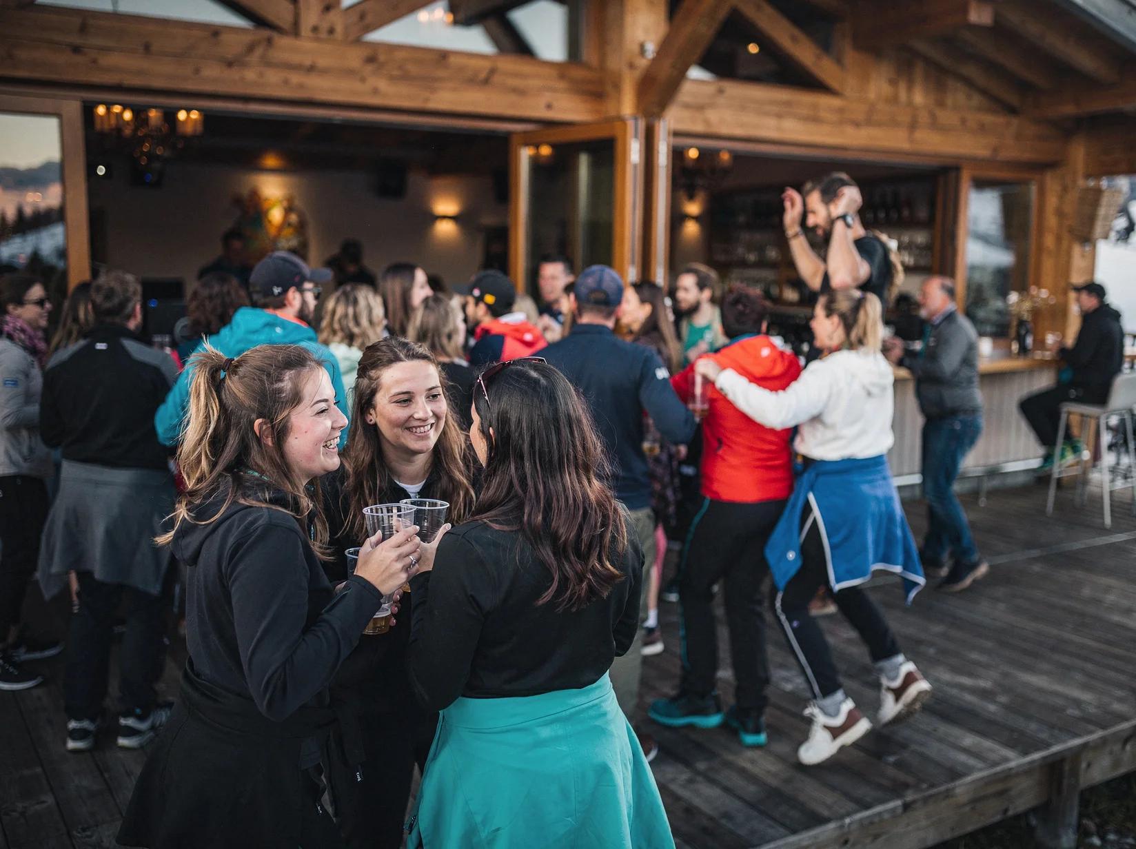 Guests dancing and toasting at the peak of an apres-ski party in a mountain lodge bar