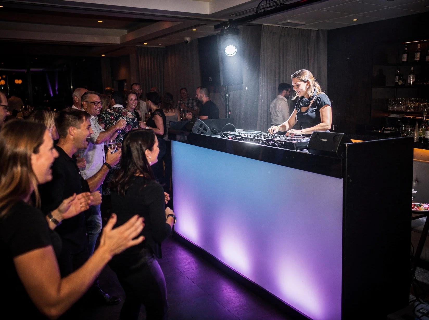 DJ aan het werk achter de booth terwijl gasten dansen bij het DJ huren in Apeldoorn