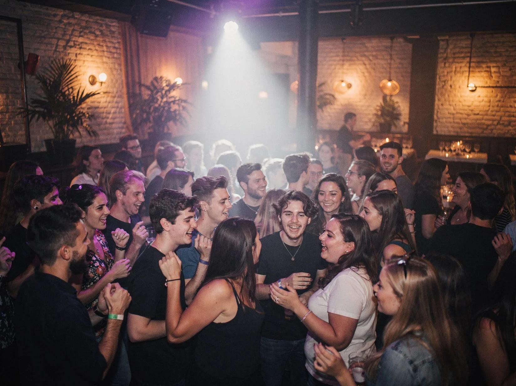 Druk studentenfeest met dansende jongeren waar je een DJ kunt huren in Gent