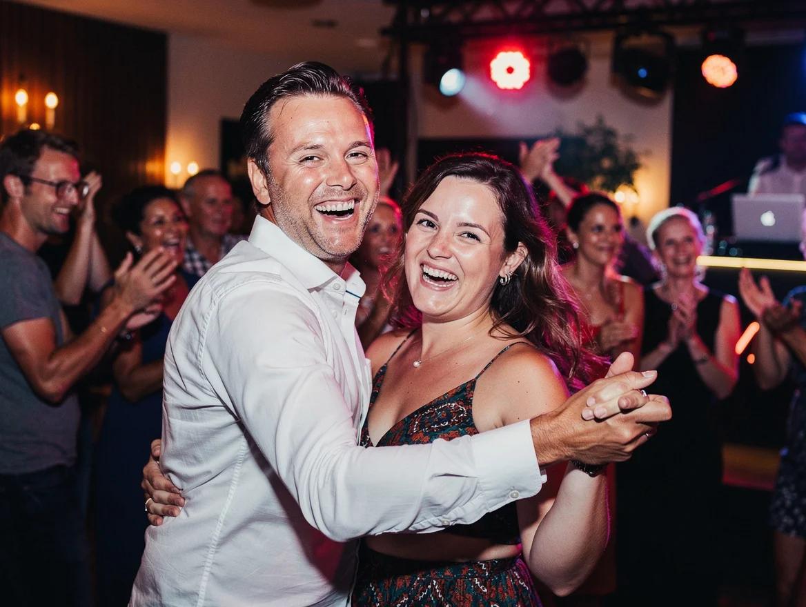 Gasten dansen uitgelaten op een feest met een DJ in Haarlem.