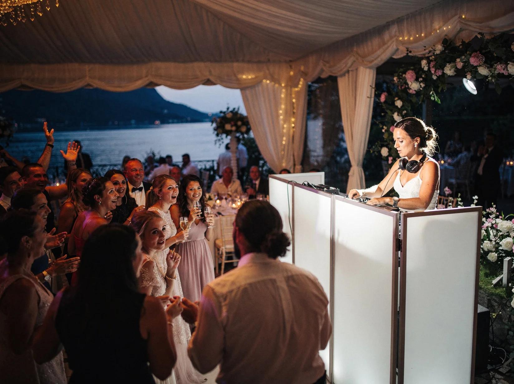 Guests dancing at a Lake Como wedding while an Italian DJ mixes behind a sleek booth