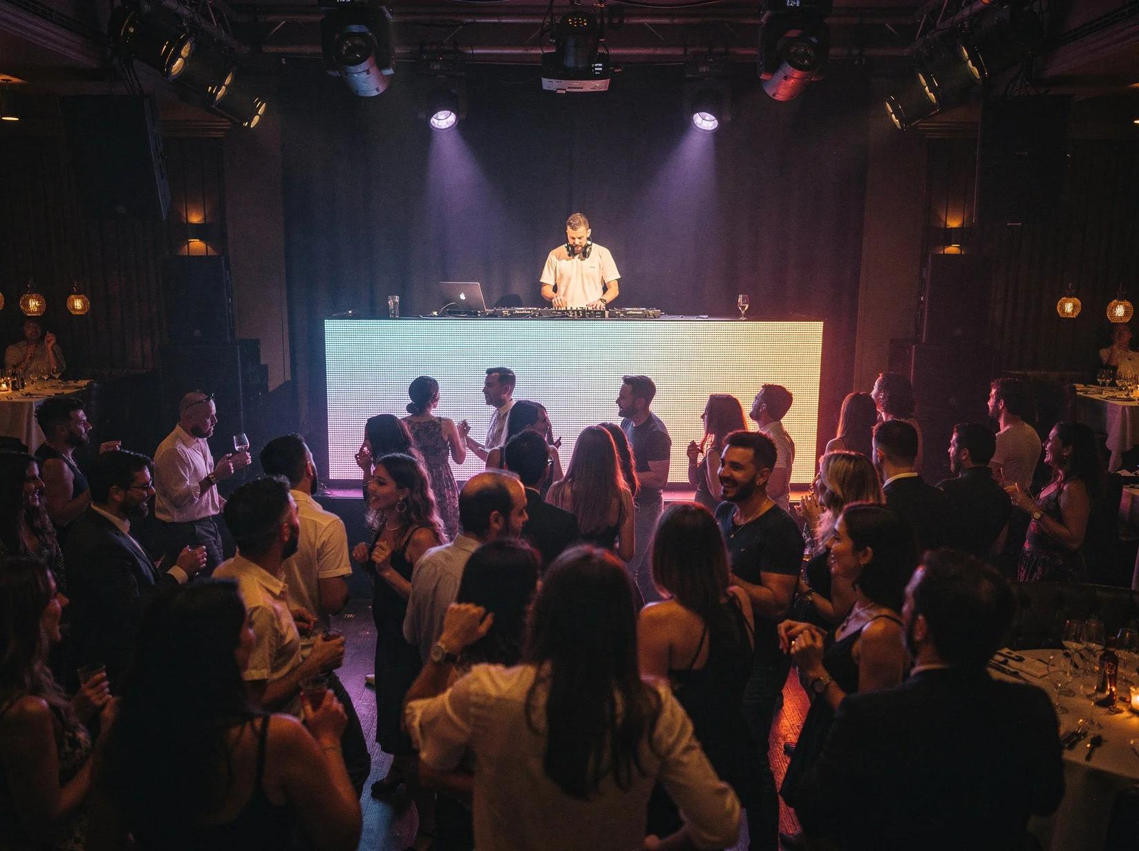 Crowd dancing in a Barcelona club while a DJ performs, showing how you can book DJs anywhere in Spain