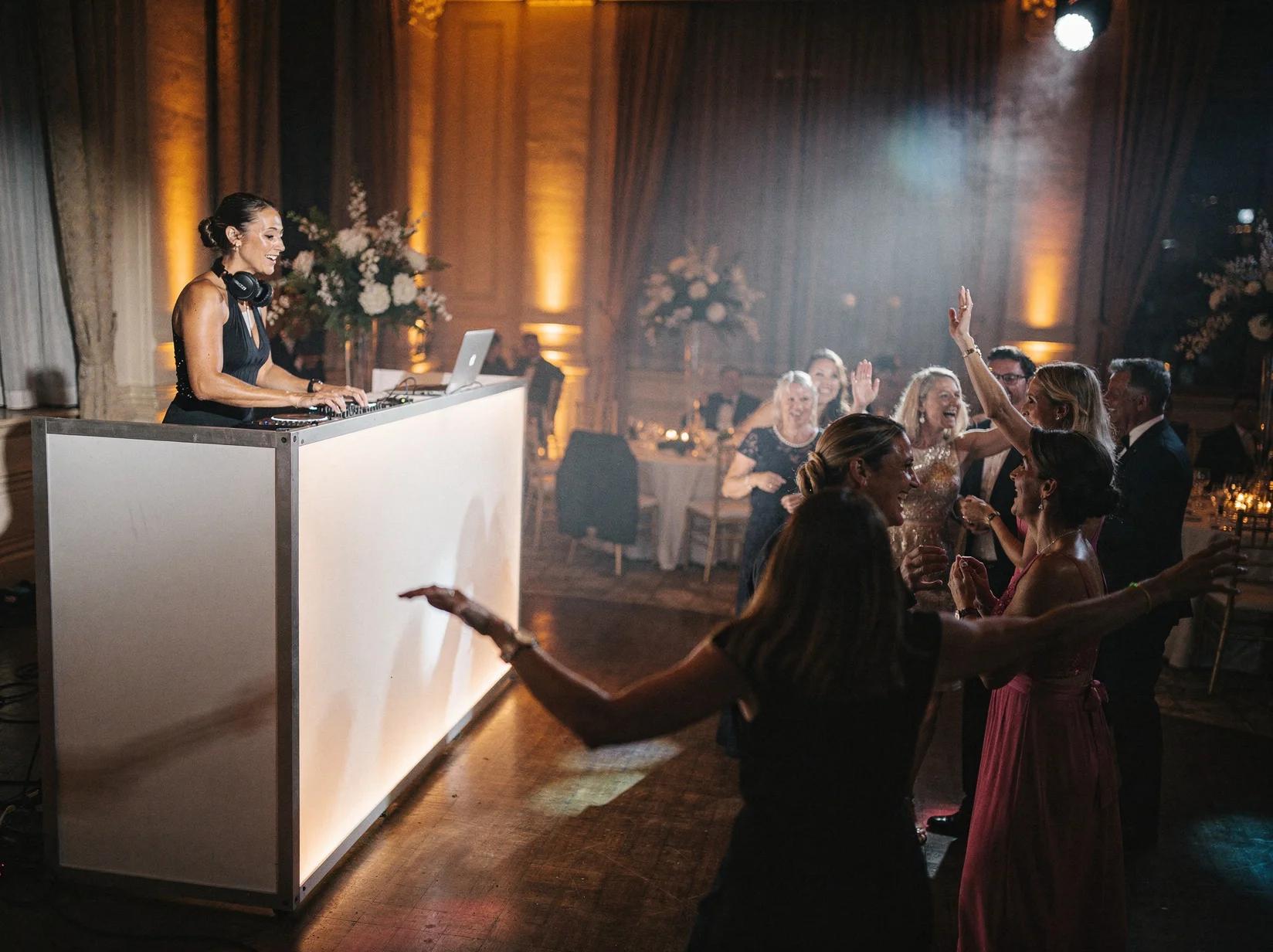 Gala DJ aan het werk terwijl goedgeklede gasten op de dansvloer dansen tijdens een stijlvol gala