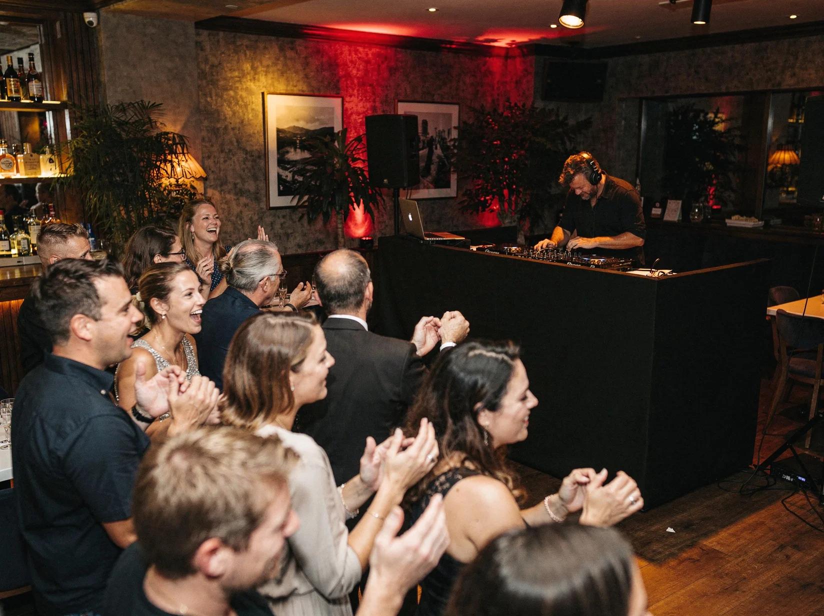 DJ aan het werk in een gezellige horecazaak terwijl gasten dansen op de vrijdagavond