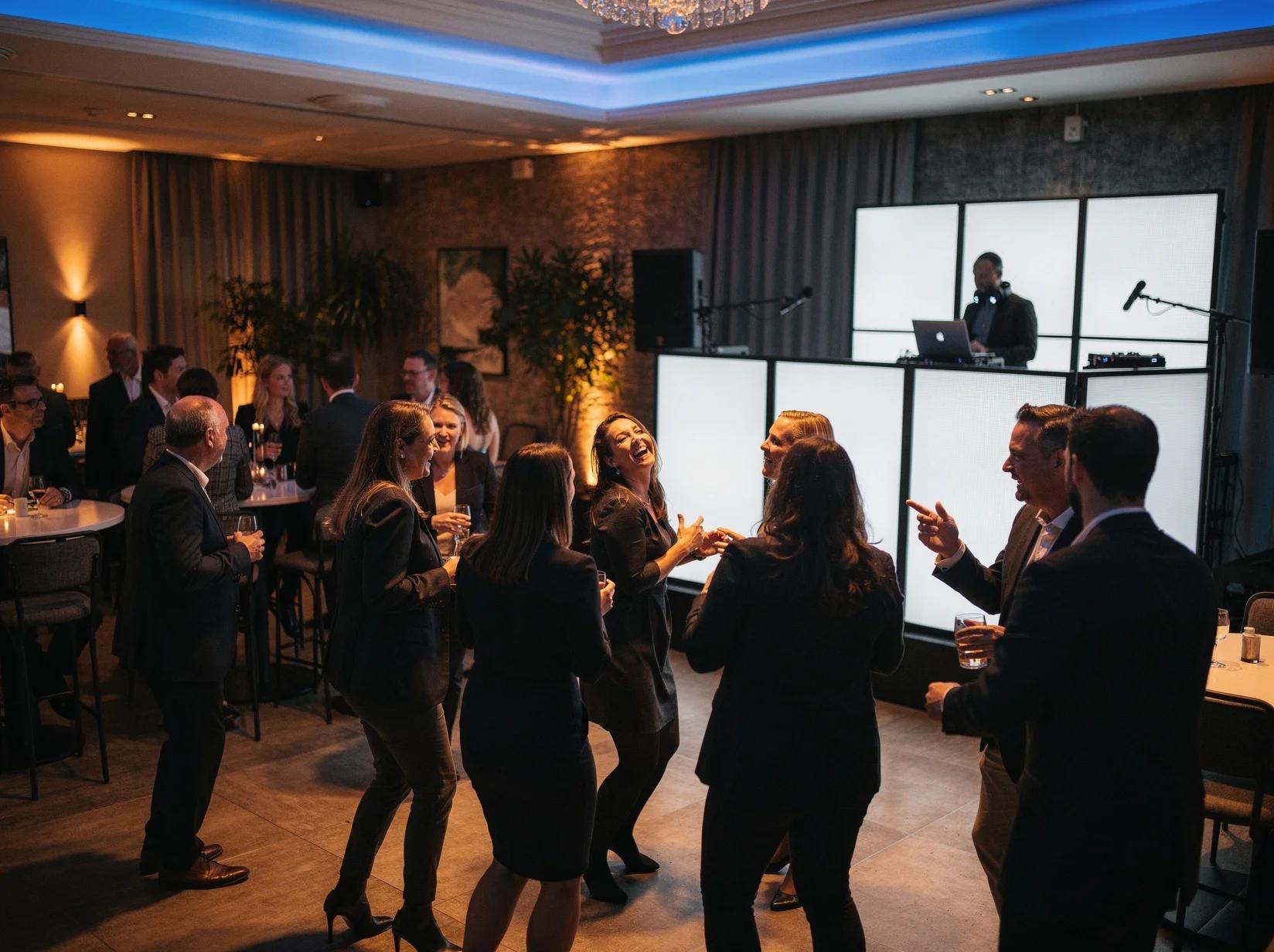 Collega's en relaties die sfeervol samen het jaar openen op een nieuwjaarsborrel met een DJ in een stijlvolle feestzaal