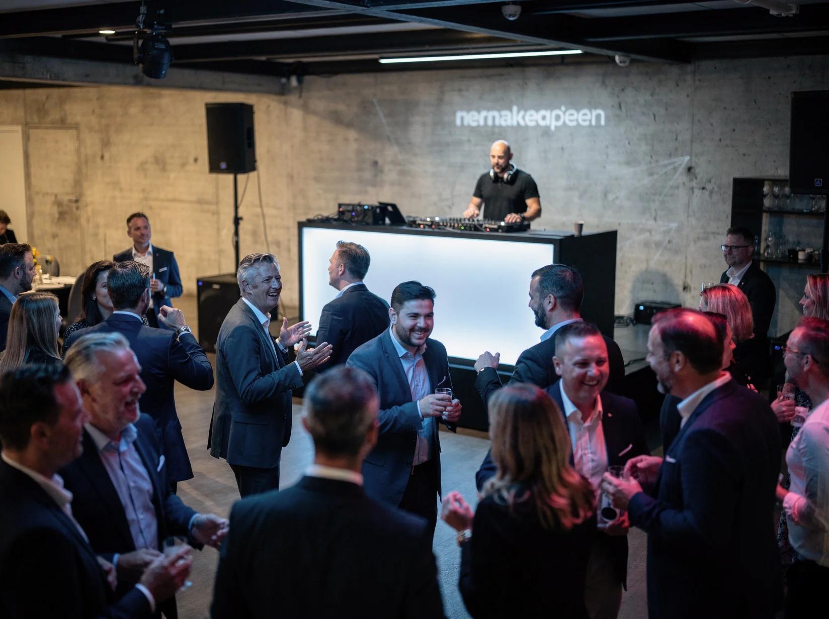 DJ zet de sfeer tijdens een productlancering terwijl gasten dansen op de opening