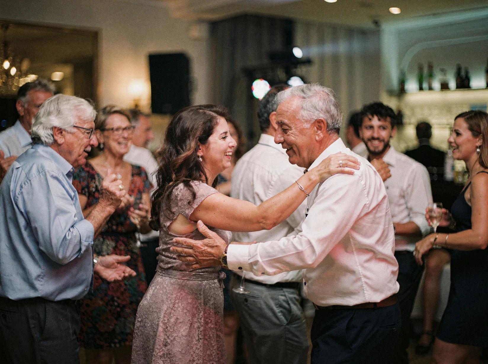 A party DJ matches the music to every generation as young and older guests dance together on the floor