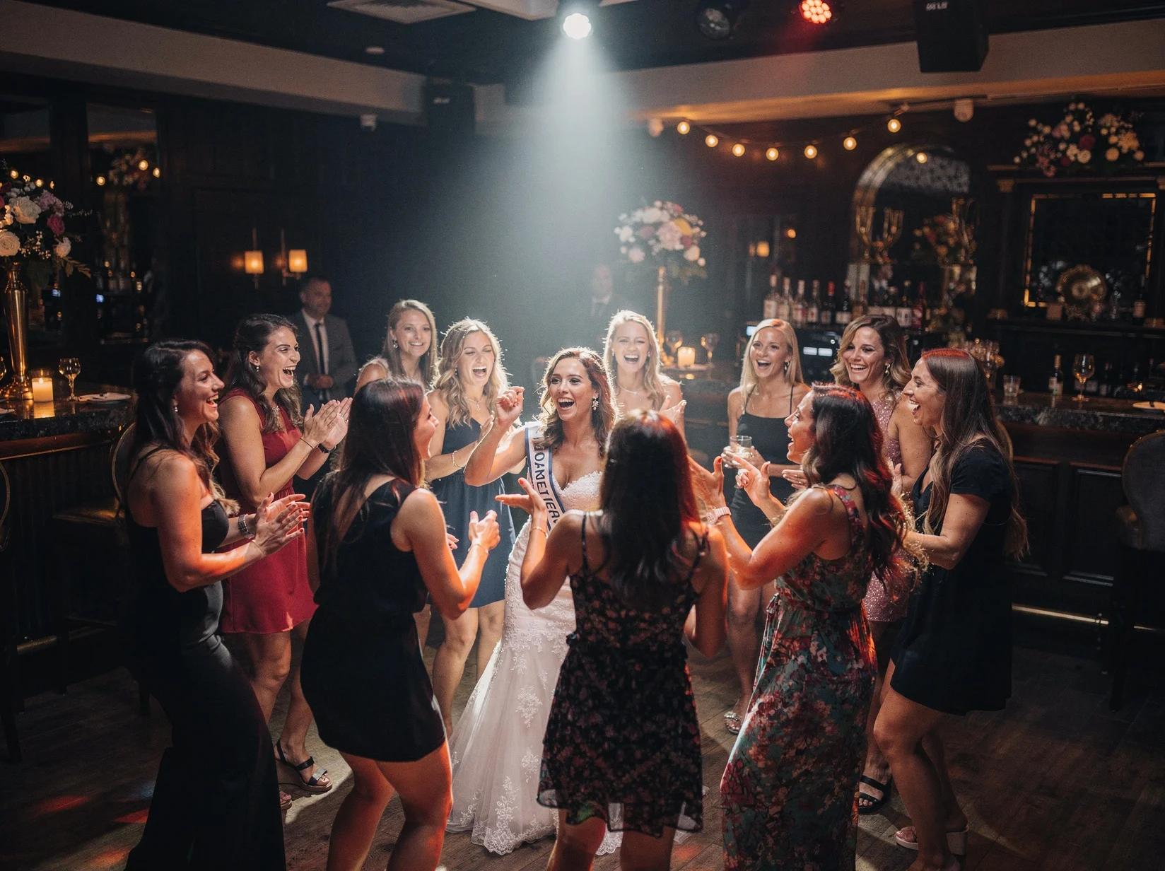 Vriendengroep danst uitbundig tijdens een vrijgezellenfeest in een sfeervolle zaal