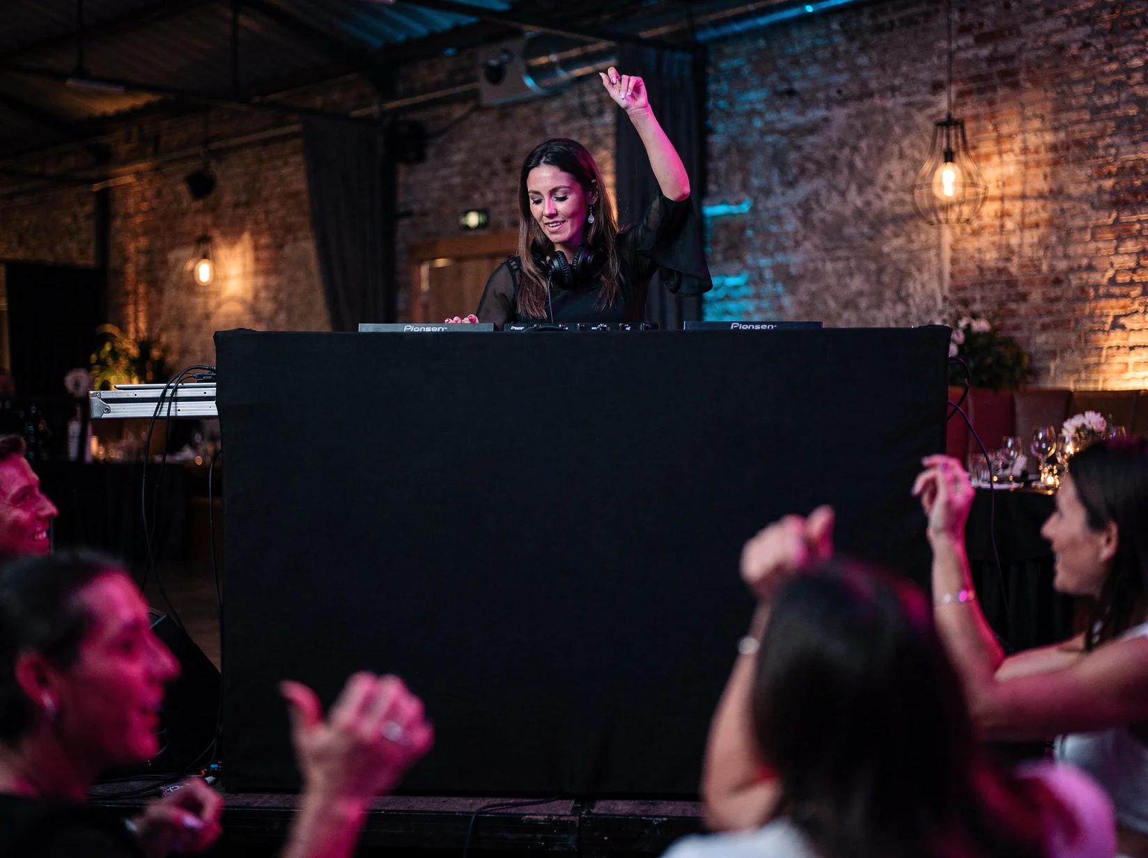 DJ mixt energiek achter de booth terwijl de groep danst op het vrijgezellenfeest